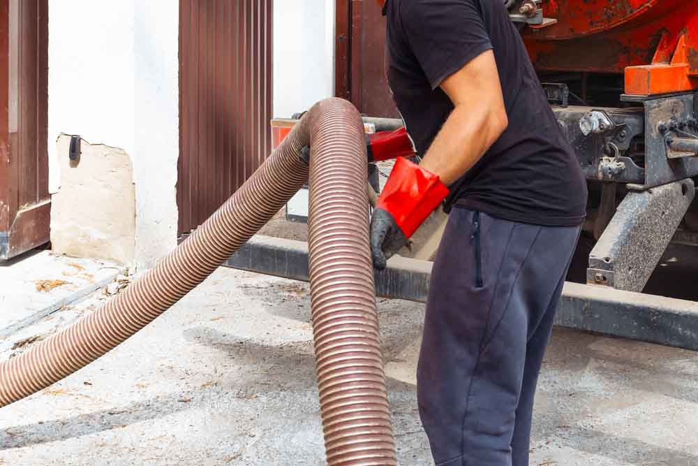 technicians carrying septic pumping gear